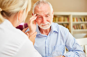 Senior adult and family member reviewing papers together for Minneapolis Clinic of Neurology