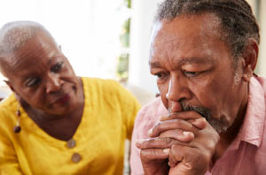 Doctor consulting with patient and caregiver about memory concerns.